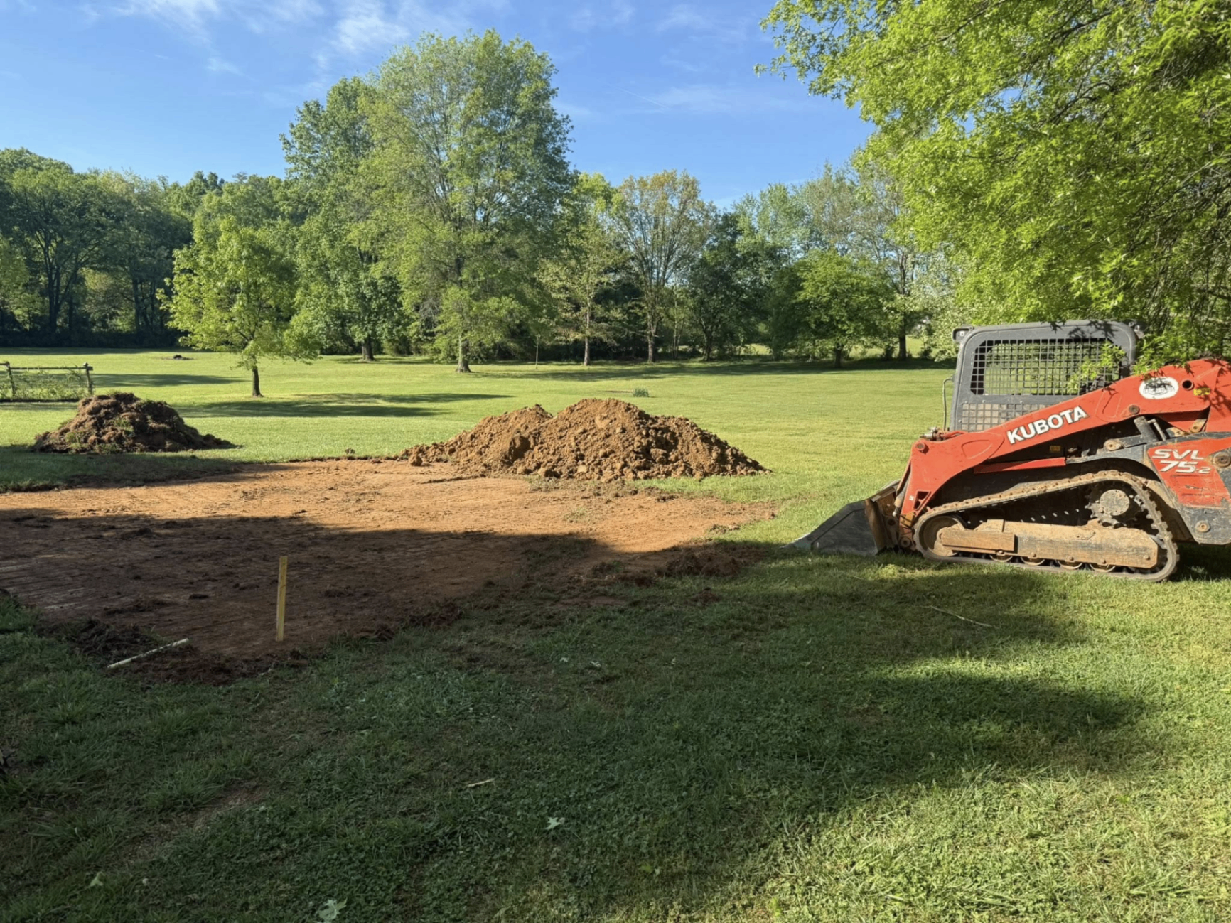 Building pad excavated and graded with skid steer in an open field