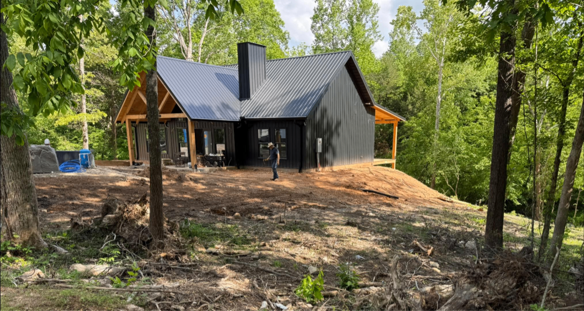 Cleared and graded home site with new black cabin in East Tennessee