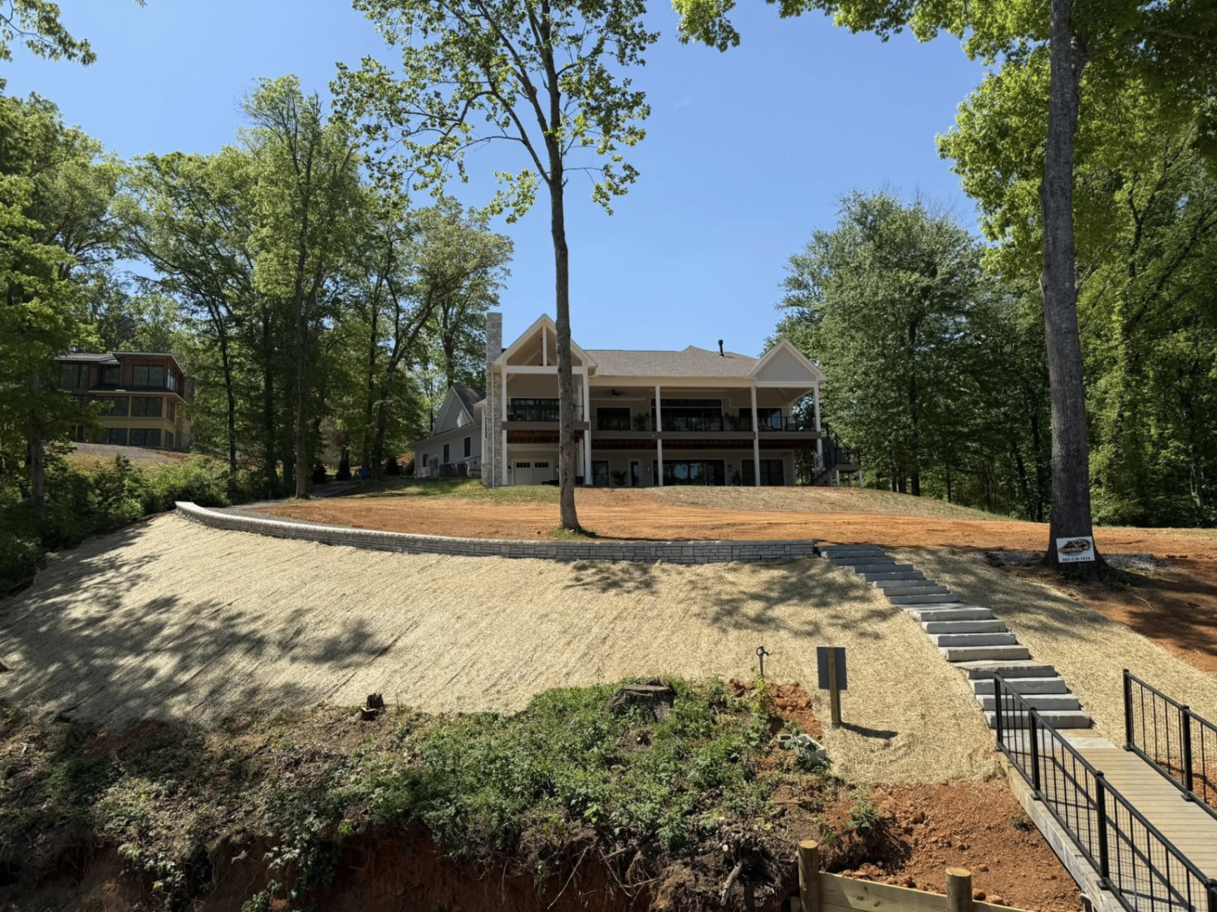 Lakehouse hillside graded and seeded with retaining wall and stone steps