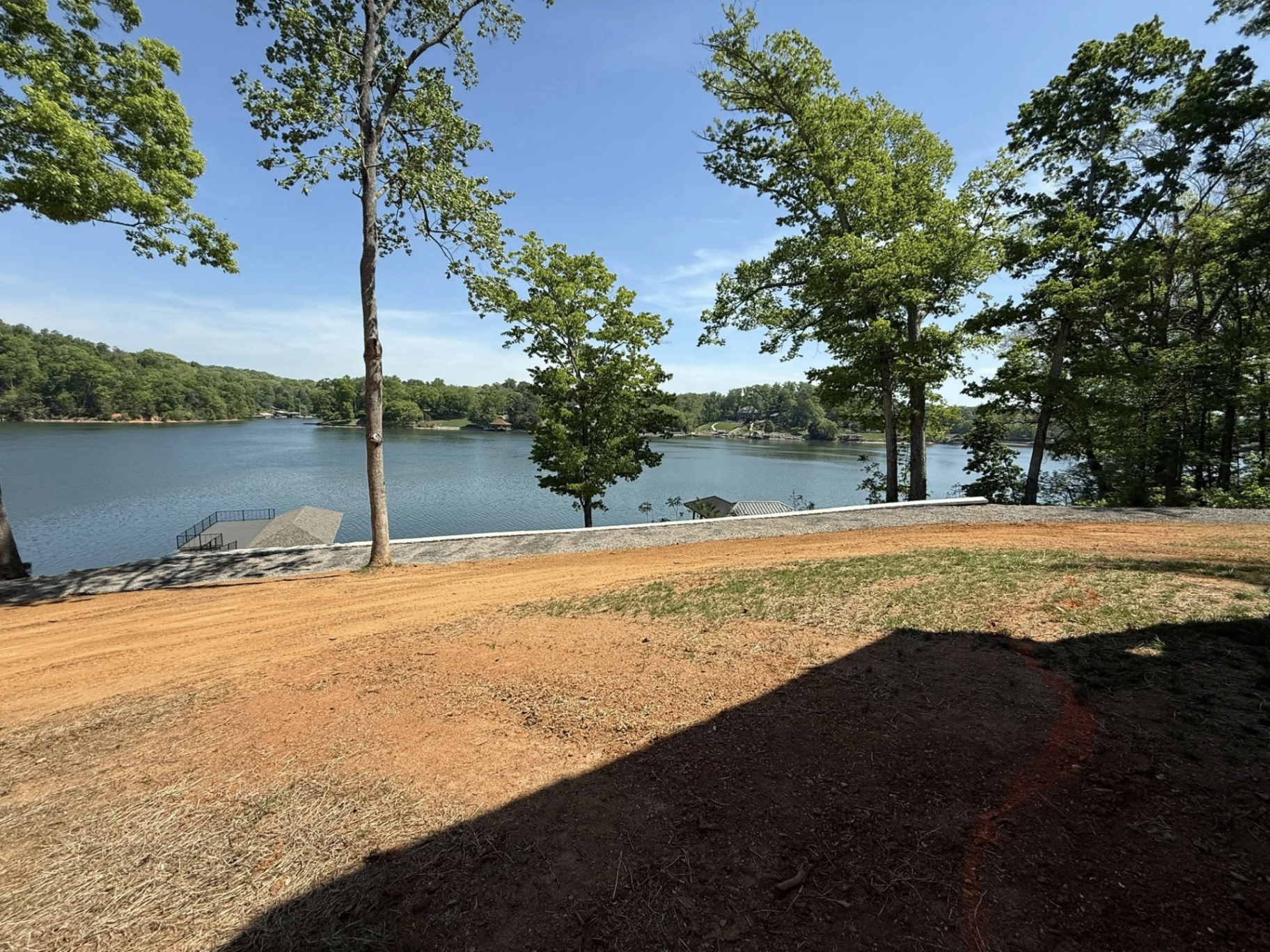 Lakeside graded shoreline with fresh gravel edge and retaining wall work