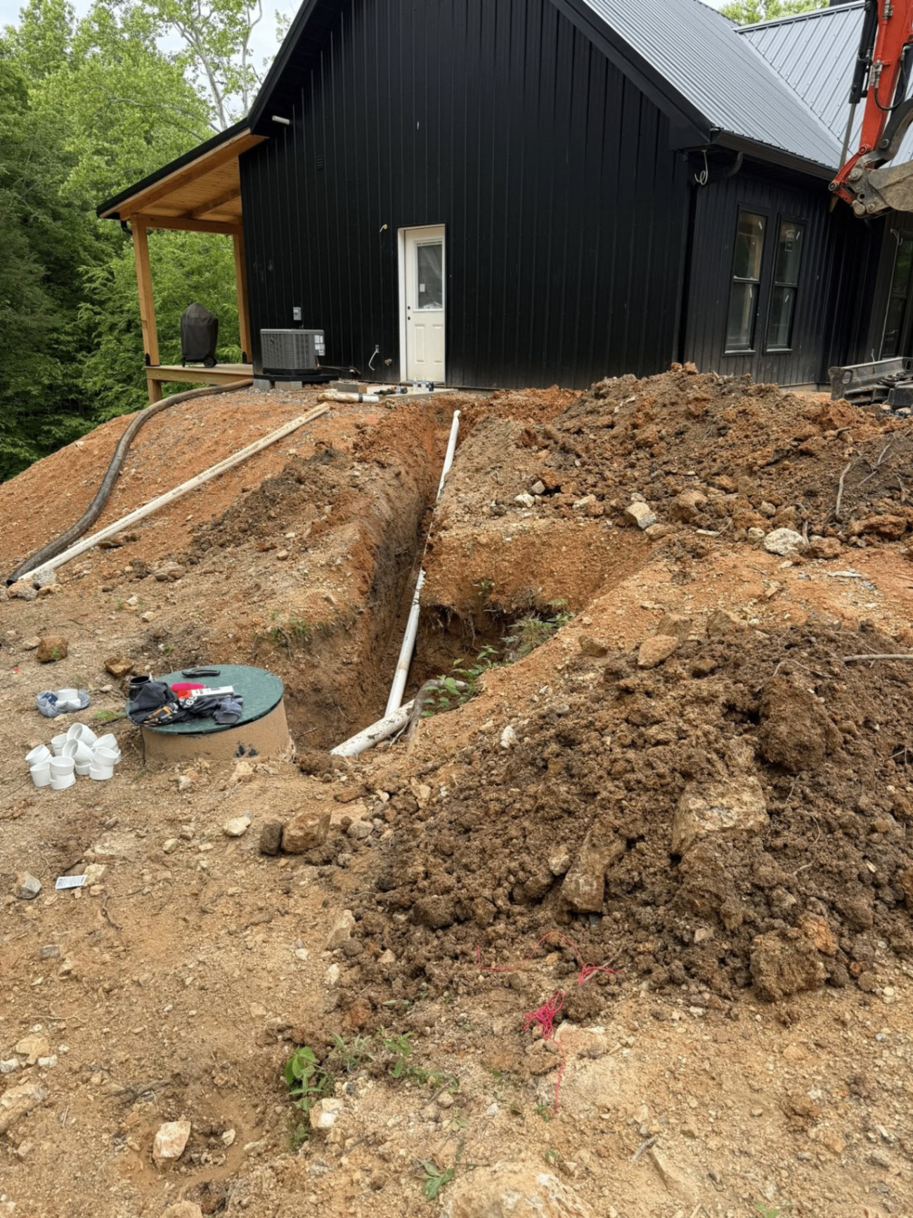 Septic tank set with drain field trenches dug to grade